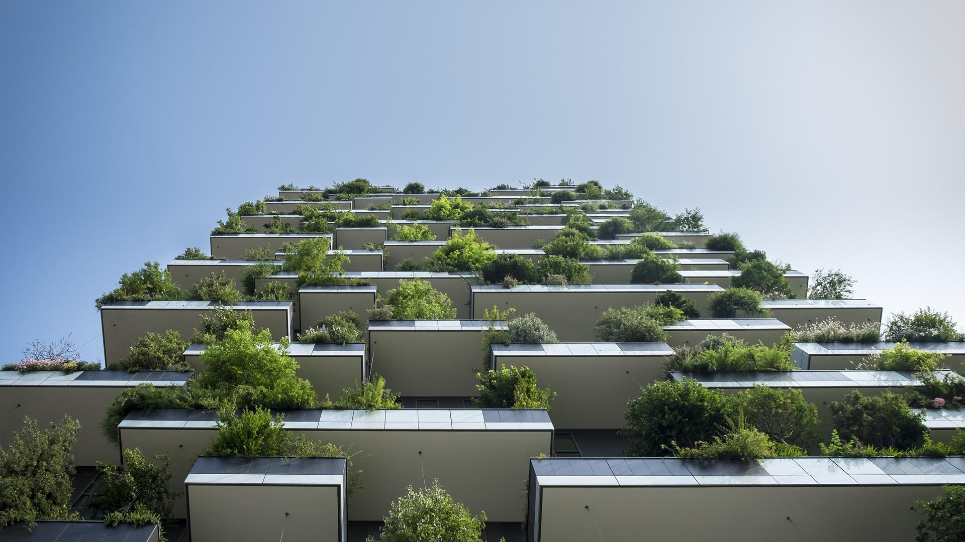 Modern flatgebouw met veel groen op de balkons.